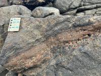 Rocha gnaisse granulitico, com bandamento (N200°/68°NW, N350°/34°NE)e foliação.